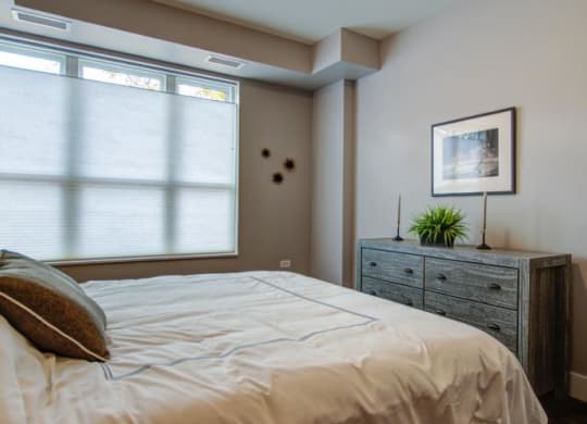 a bedroom with a bed and a dresser and a window at Barrington 101, Barrington Illinois