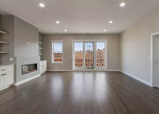 an empty living room with a fireplace and a window