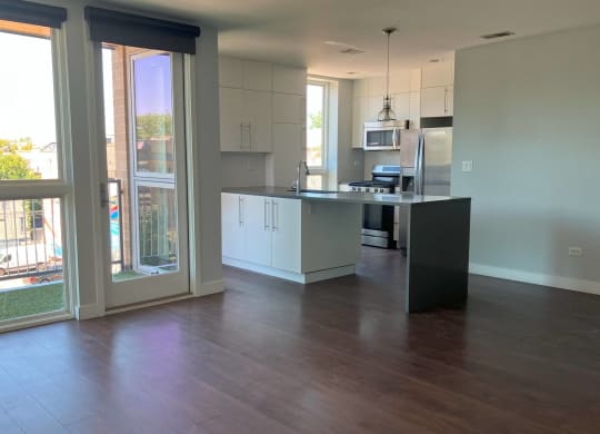 an open kitchen and living room with a wooden floor