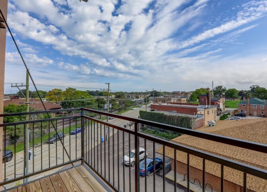 a balcony with a view of a city and a blue sky