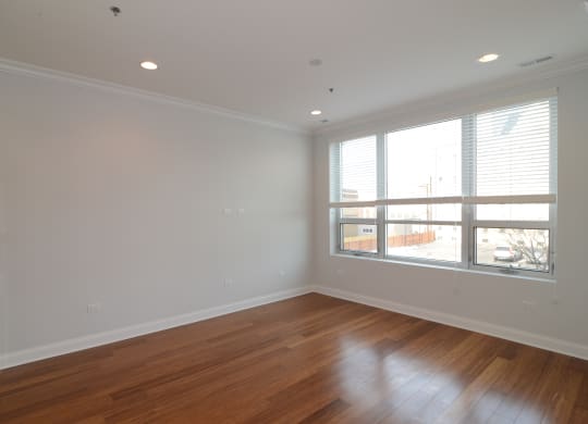a living room with wood floors and a large window