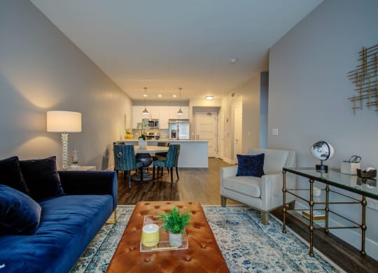 a living room with a blue couch and a coffee table in front of a kitchen at Barrington 101, Chicago