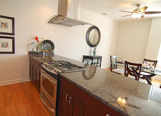 a kitchen with a granite counter top and a dining room with a table and chairs