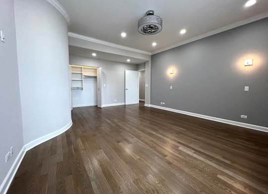 a living room with a hard wood floor and grey walls