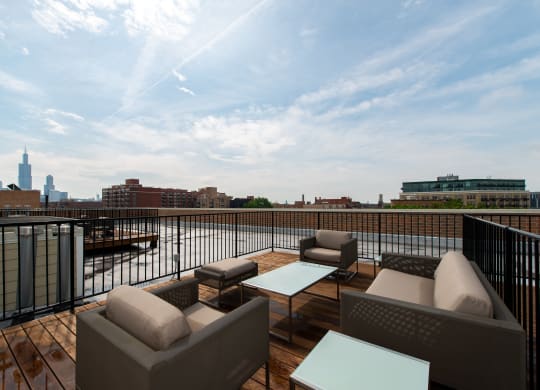 a rooftop deck with couches and tables overlooking a river and the city  at Tripp 4321, Chicago, IL
