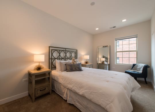 a bedroom with a bed and a chair and a window