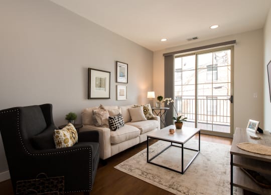 a living room with a couch and a chair and a window