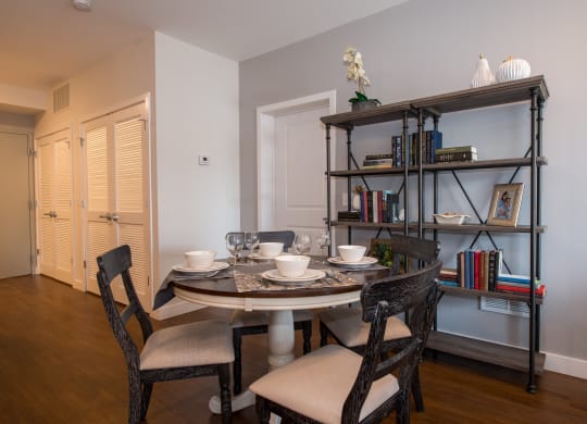 a dining room with a table and chairs and a bookshelf