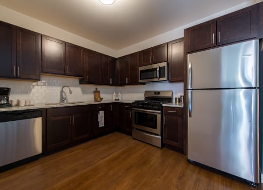 a kitchen with stainless steel appliances and dark wood cabinets