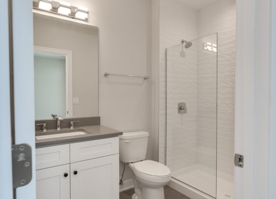 a white bathroom with a shower toilet and sink