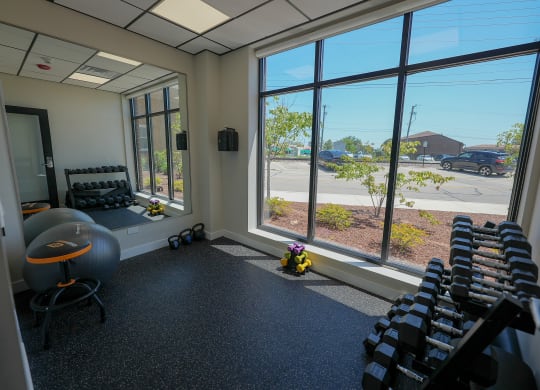 a fitness room with rows of chairs and large windows