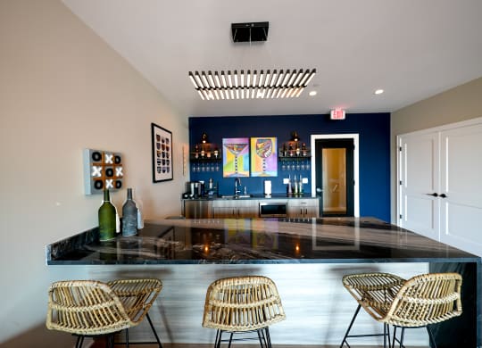 a bar with chairs and a blue wall in a room with a glass counter top