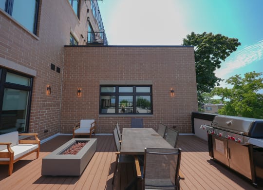 a backyard patio with a barbecue grill and a table and chairs