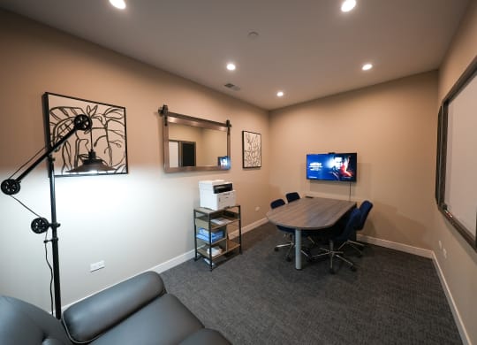 a conference room with a table and a tv