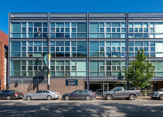 A modern building with a parking lot in front of it.