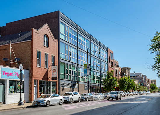 A street view with a vegan pizza shop on the corner.