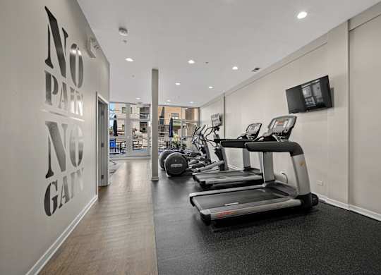 A gym with treadmills and a wall that says