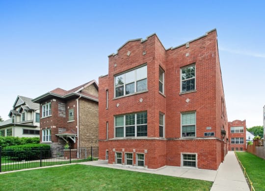 a red brick building with a sidewalk in front of it