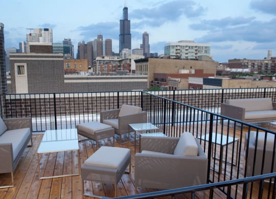 a rooftop deck with furniture and a city in the background  at Tripp 4321, Chicago, 60641