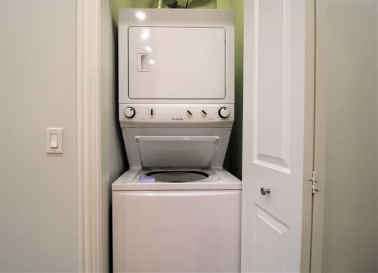 A white washing machine is in a small laundry room.