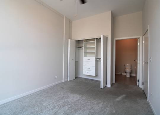 an empty bedroom with a closet and a toilet