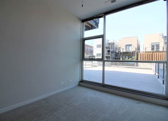 an empty living room with a large window and a balcony