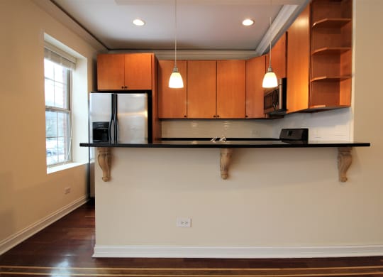 a kitchen with a black counter top and wooden cabinets