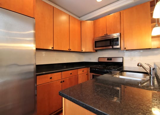 the kitchen has granite counter tops and stainless steel appliances