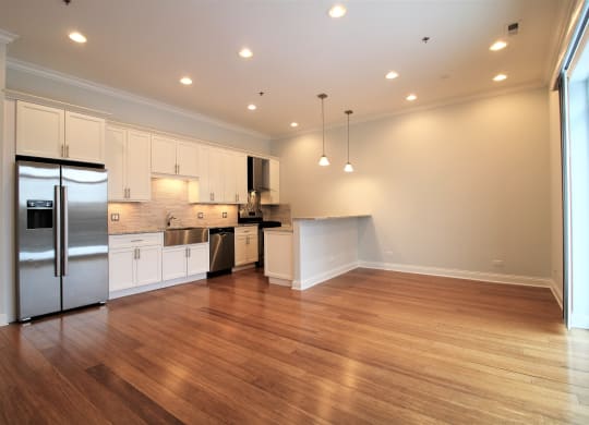 A kitchen with wooden floors and white cabinets.