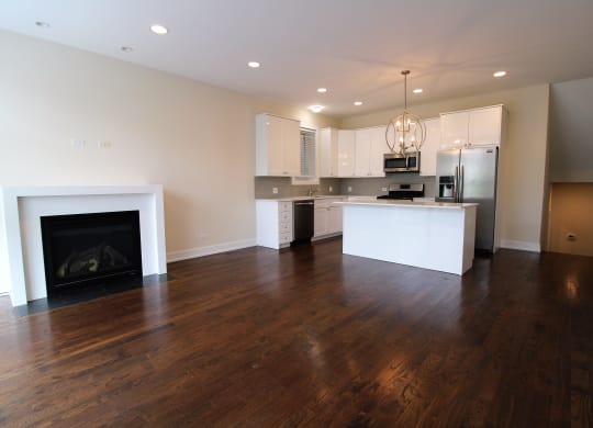 a living room with a fireplace and a kitchen