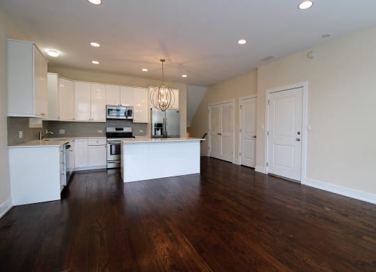 an empty kitchen with white cabinets and a counter top
