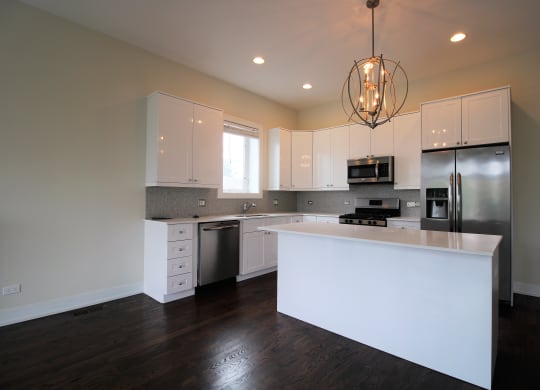 a kitchen with white cabinets and stainless steel appliances