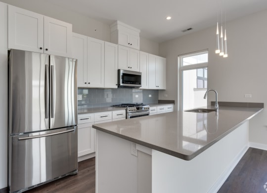 a kitchen with white cabinets and stainless steel appliances