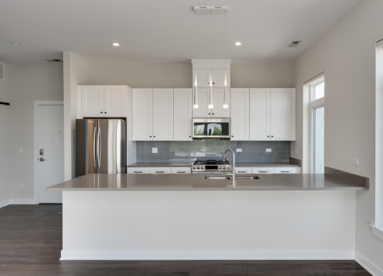 a kitchen with white cabinets and a large counter top