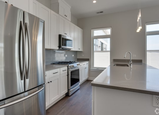 a kitchen with stainless steel appliances and white cabinets