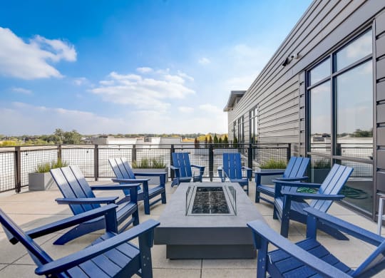 a patio with blue chairs and chairs around a fire pit at Barrington 101, Chicago