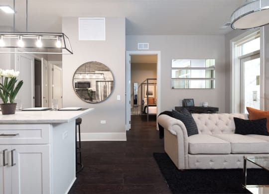 a living room with a white couch and a kitchen