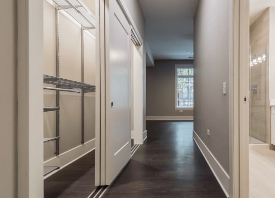 a hallway with a closet and a sink and a mirror
