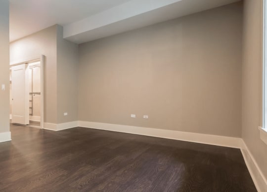 an empty living room with wood floors and white walls
