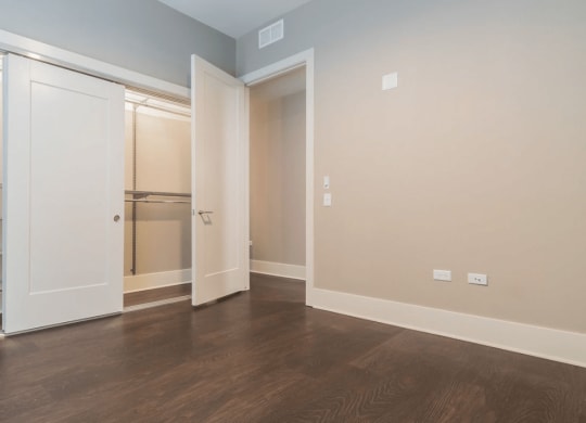 a bedroom with a closet and a hard wood floor