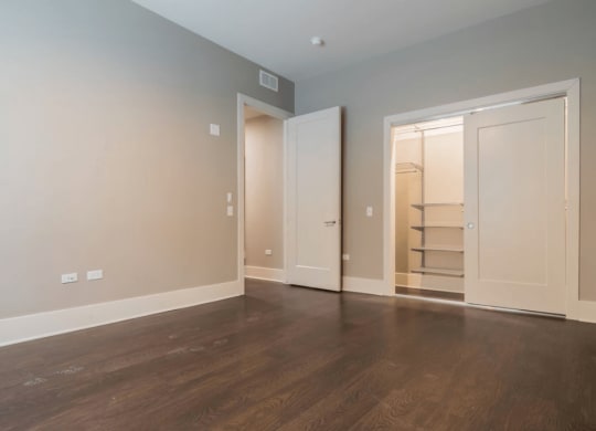 an empty living room with wood floors and a closet