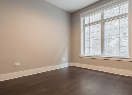 an empty room with wood floors and a window