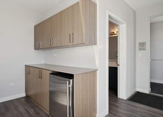 Community room kitchen at Highpoint Buena Park on Broadway with stainless steel appliances, bar seating, and modern cabinetry in a stylish shared space for residents in Chicago’s Buena Park neighborhood
