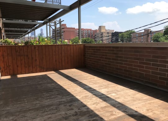 a small patio with a brick wall and a wooden floor