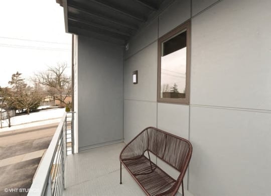 a chair sitting on a balcony next to a building