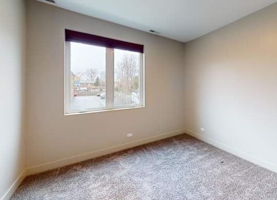 A room with a carpeted floor and a window.
