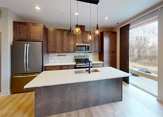 A modern kitchen with a large island and wooden cabinets.