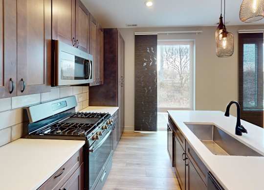 A kitchen with a stove top oven and a microwave above it.