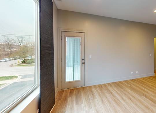 A room with a wooden floor and a white door.