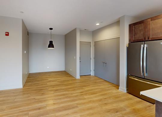 A kitchen with a refrigerator, sink, and cabinets.
